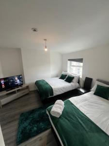 een kamer met 2 bedden en een flatscreen-tv bij City Urban Apartments in Birmingham