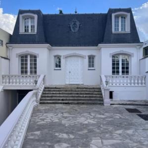 uma casa branca com uma porta branca e escadas em Jolie demeure proche stade de France em Drancy