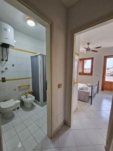 a bathroom with a toilet and a shower and a sink at Appartamento Girasole in San Vito lo Capo