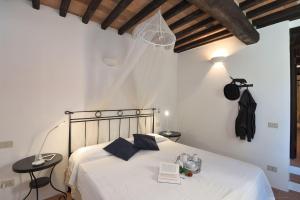 a bedroom with a white bed with a book on it at Mantegna in Gaiole in Chianti