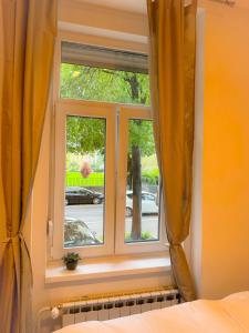 a bedroom with a window with yellow curtains at Apartman No. 2 in Zagreb