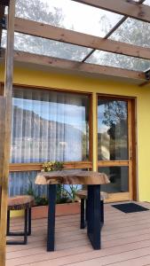 a wooden bench on a deck with a window at Casa del Oro in Suesca