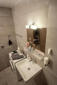 a white bathroom with a sink and a mirror at Apartmán víla Amálka in Janov nad Nisou