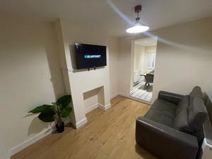 a living room with a couch and a television on a wall at The Big 3 Bedroom London House 2 bathrooms in Woolwich