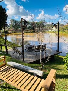a wooden dock with benches next to a lake at Park Hotel Modelo in Pinhalzinho