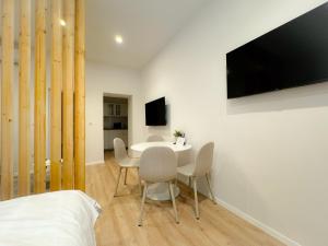 Una habitación con una mesa y sillas y un televisor. en Apartman No. 2, en Zagreb