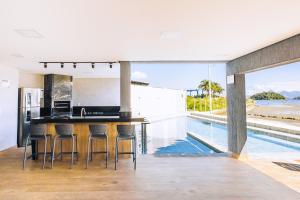 eine offene Küche mit einer Bar und einem Pool in der Unterkunft VELINN Angra Sunset Hotel & Villas in Angra dos Reis