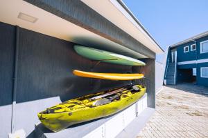 Tres kayaks están al lado de un edificio en VELINN Angra Sunset Hotel & Villas, en Angra dos Reis