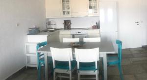 a kitchen with a table and chairs and a kitchen with white cabinets at Sunset Villa with swimming pool at Tzia in Ligia