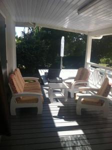 eine Gruppe Stühle auf einer Veranda in der Unterkunft Taravao Belvedere maison 3ch calme avc Piscine+2 bungalow 15 min Teahupoo wave in Tohautu
