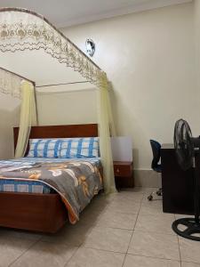 a bedroom with a bed and a desk in a room at MiniPalais Bukoto in Kampala