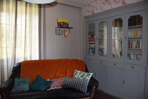 ein Wohnzimmer mit Sofa und Bücherregal in der Unterkunft Domaine chez Maurice in Bécheresse