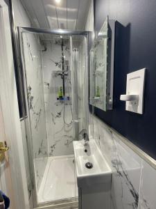 a white bathroom with a shower and a sink at 3 BR 5 min walk from Hertfordshire University in Hatfield in North Mimms