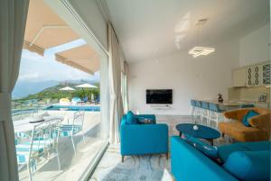 a living room with blue furniture and a view of a pool at Villa23_Blizikuce in Blizikuće