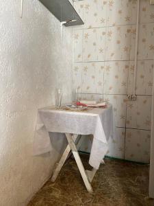 een tafel met een witte tafelkleed in een kamer bij Tres Lunas Alojamiento Individual in Chuy