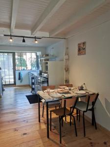 a room with a table with chairs and a kitchen at la maison du bonheur in Seignosse