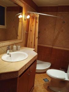 La salle de bains est pourvue d'un lavabo, de toilettes et d'un miroir. dans l'établissement Klio's apartment, à Lávrio