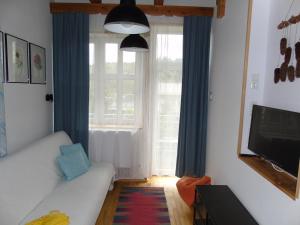 a living room with a white couch and a window at Villa-Bajka in Wisła