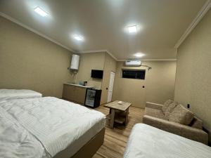 um quarto de hotel com uma cama, um sofá e uma mesa em VARDANANTS HOTEL Meghri em Meghri