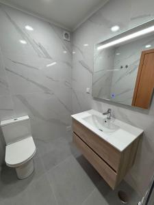 een badkamer met een wastafel, een toilet en een spiegel bij Lisbon Location in Lissabon
