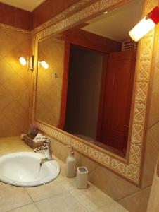 La salle de bains est pourvue d'un lavabo et d'un grand miroir. dans l'établissement Klio's apartment, à Lávrio
