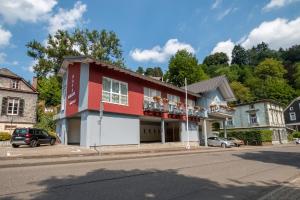 ein rot-weißes Gebäude an der Straßenseite in der Unterkunft Haller Hotel Garni in Monschau