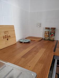 une cuisine avec un plan de travail en bois et un sol en bois dans l'établissement Studio cosy classé 3 étoiles dans cœur historique, à Arreau