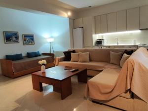 a living room with a couch and a table at Klio's apartment in Lavrio