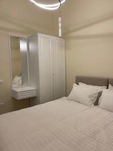 a bedroom with a white bed and a mirror at Top Villas Durres in Durrës