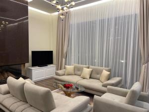 a living room with a couch and a tv at Top Villas Durres in Durrës
