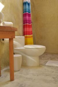 a bathroom with a toilet and a rainbow shower curtain at Las Casas Chiapas in San Cristóbal de Las Casas +37 photos