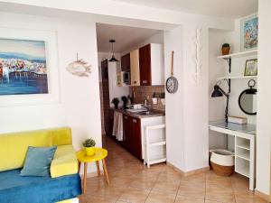 a kitchen and a living room with a couch at Apartment Megi in Supetar historical core in Supetar