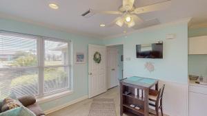 a living room with a ceiling fan and a table at JEKYLL KEEPERS QUARTERS apts in Jekyll Island