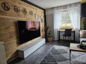 a living room with a large flat screen tv on a wooden wall at Ferienwohnung Ache in Oetz