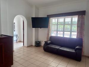 クリアカンにあるInHouse Select Hacienda Tres Riosのリビングルーム(黒い革張りのソファ、窓付)