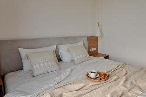 Una cama con una bandeja con un tazón. en Om Cemagi Beach Villa Canggu en Tanah Lot