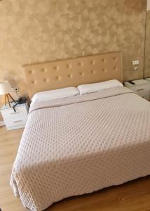 um quarto com uma cama com um edredão branco em Hotel Holiday em Nigrán