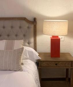 una lámpara roja en una mesa junto a una cama en HOTEL RURAL SANTUI, en Horcajuelo de la Sierra
