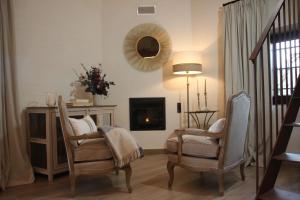 sala de estar con 2 sillas y chimenea en HOTEL RURAL SANTUI en Horcajuelo de la Sierra
