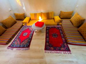 een woonkamer met een bank met rode kussens bij Cozy Tamraght 1 Bedroom apartement in Tamraght Ouzdar