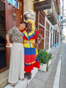 two women standing next to each other on a street at Hostal Casa de las Americas in Cartagena de Indias