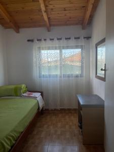 a bedroom with a green bed and a window at Diarla's Home 1 in Fier