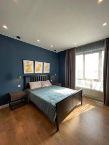 1 dormitorio con 1 cama grande y pared azul en Stylish living in Downtown UB, en Ulán Bator