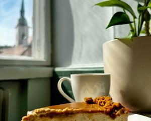 a piece of cake sitting on a table next to a coffee cup at Extralarge Queen Room in the Heart of Bratislava with Terrace in Bratislava
