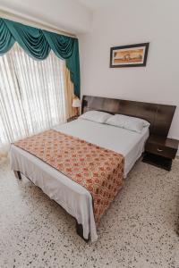 sypialnia z dużym łóżkiem i oknem w obiekcie Casa Hotel Miriam w mieście Montería