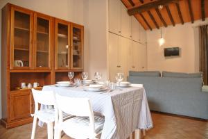 a table with chairs and wine glasses on it at Agonigi Apartment Torre di Pisa in Pisa
