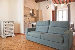 a living room with a couch and a kitchen at Agonigi Apartment Torre di Pisa in Pisa