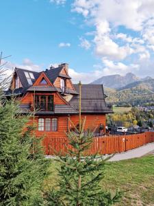 a wooden house with a fence in front of it at Góralska Prowincja in Kościelisko