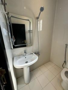 a bathroom with a sink and a mirror and a toilet at أجنحة دارنـــــا للـــشقق الــمــفــروشــة in Abha