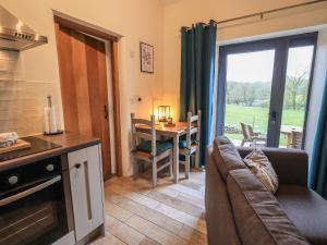 a kitchen and living room with a couch and a table at Speight Cottage in Sedbergh